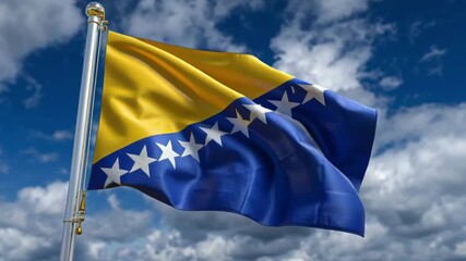 The flag of Bosnia Herzegovina waves displaying gold blue with white stars against a cloudy blue sky