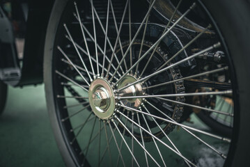 Fototapeta premium Skinny spoke wheel of a vintage veteran car on a motor show in Brighton, East Sussex, UK