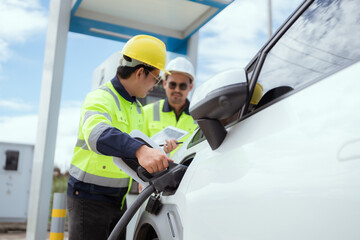 Workers operating an electric vehicle charging station in a sunny outdoor environment