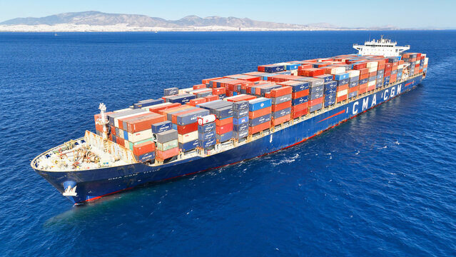 Aerial drone flight near GMA - CGM colorful truck size container ship cruising in deep blue sea of Saronic Gulf, Piraeus, Attica, Greece