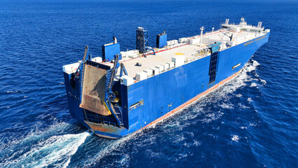 Aerial drone photo of RoRo (Roll on Roll off) vehicle carrier ship cruising in open ocean deep blue...