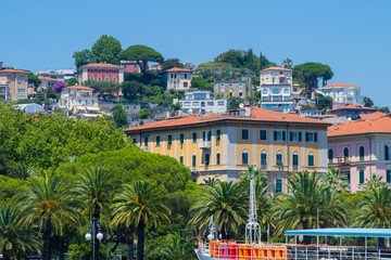 Palm trees and multicolor houses on the waterfront street of the Italian city of La Spezia. Italia...