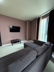 Minimalist living room with dark sofa and wall-mounted TV