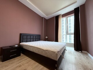 Cozy modern bedroom with large window and hardwood floor