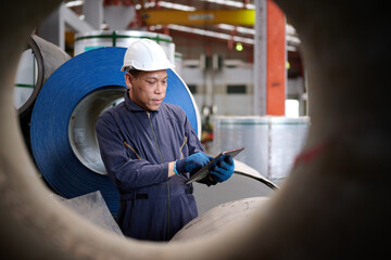 Technician or worker working on tablet and checking Sheet metal products in the factory