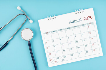 August 2026 desk calendar and stethoscope on blue color, Medical appointment concept.