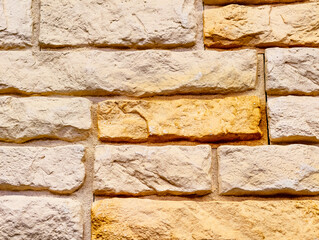 Elegant Beige and Golden Stone Wall Background with Textured Finish for Inviting Digital Designs. High-Resolution Wallpaper and Screensaver for Phones, Tablets, Laptops, and Marketing