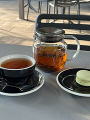 Teapot cup of tea dessert on a served table in a cafe. The atmosphere is cozy and welcoming.