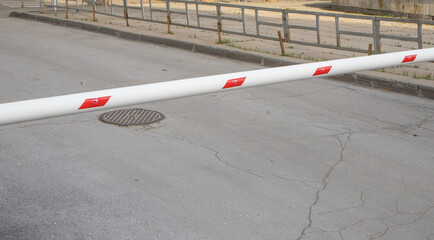 Red and white metal barrier, blocking the road, protecting the territory, controlling entry