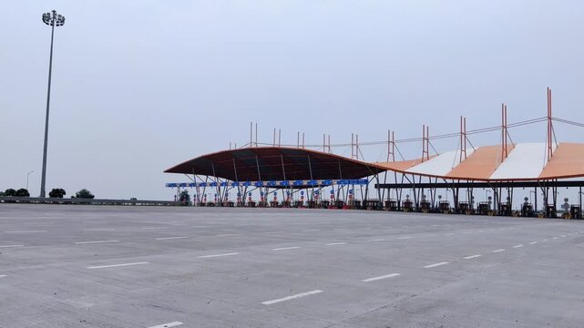 Footage of Delhi Vadodara Mumbai Expressway road and Toll Plaza shot against a beautiful cloudy sky

