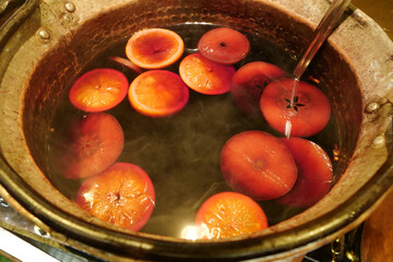 Hot mulled wine with orange and with persimmon