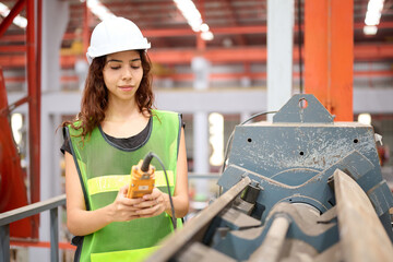 Engineer or worker operating remote switch to control machine in the factory