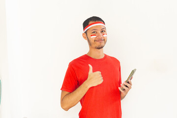 Young Indonesian man thumbs up to mobile phone with headband in isolated white