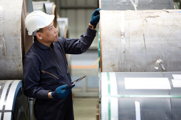 Technician or worker working on tablet and checking Sheet metal products in the factory