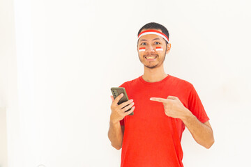 Young Indonesian man pointing to mobile phone with headband in isolated white