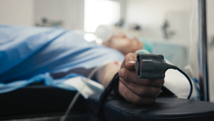 Patient lying on hospital bed with medical equipment monitoring vital signs, showcasing healthcare...