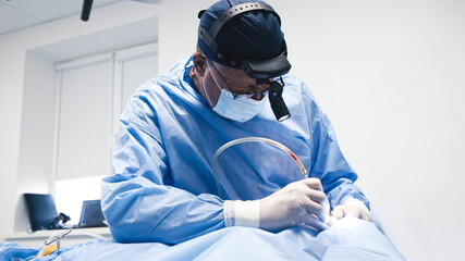 Surgeon in blue scrubs, focused on intricate procedure, utilizing advanced medical tools, with...