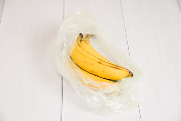 Spoiled bananas in a plastic bag on light background