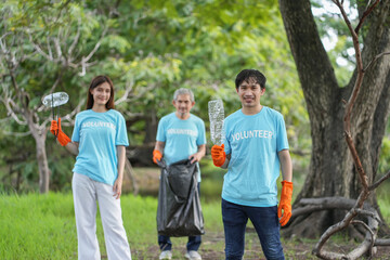portrait young asian man holding used plastic bottle with background diverse team of volunteers...