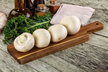 White champignon mushrooms heap over board