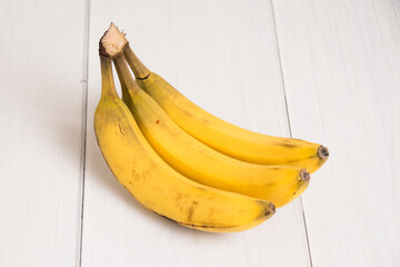 A branch of spoiled bananas on light background