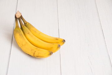 A branch of spoiled bananas on light background
