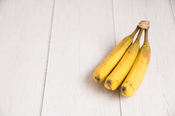 A branch of spoiled bananas on light background