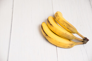 A branch of spoiled bananas on light background