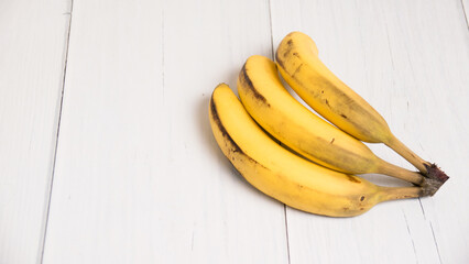 A branch of spoiled bananas on light background