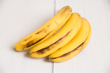 A branch of spoiled bananas on light background