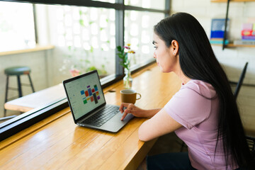 Freelancer working on laptop in coffee shop with calendar app open