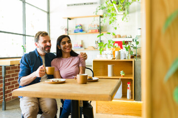 Pretty couple enjoying coffee and pastries at a cozy cafe