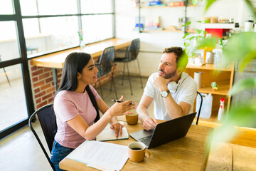 Hispanic freelancers working on a project in a coffee shop
