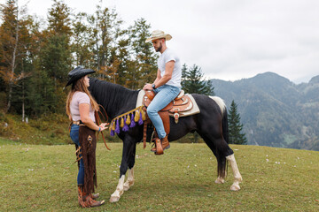 Authentic western riding school experience, cowboy learning horseback skills from a female...
