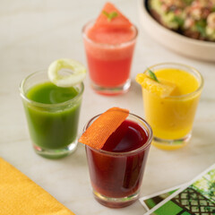 ChatGPT said:
This vibrant image features an assortment of colorful wellness shots served in small glass tumblers, including green, red, yellow, and pink juices, each garnished with fresh fruit or her