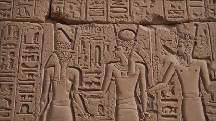 Ancient stone carvings depict figures in traditional attire and hieroglyphs - Powered by Adobe