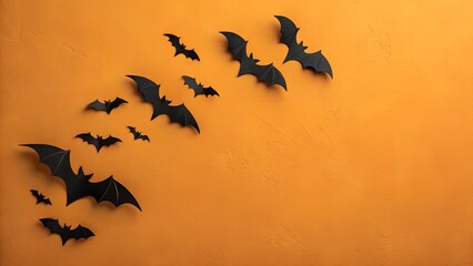 A flock of black paper bats ascending on a vibrant orange background for halloween