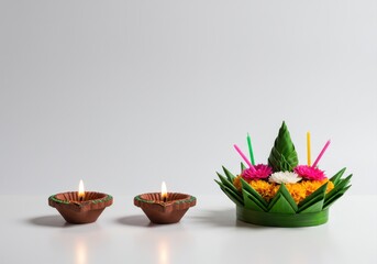 Colorful krathong with lit diyas on white background