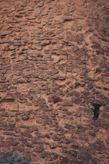 Textured stone wall with rustic patterns reflecting years of weathering and history in an ancient building