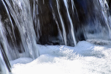 Obraz premium The view of the waterfall in a public park. Splashing Water, water flowing. Nature concept.