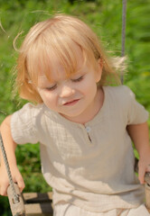 Smiling child on a wooden swing outdoors