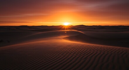 A brilliant sun sets over vast, rippled sand dunes, casting a warm orange glow across the desert landscape.