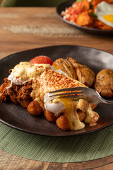 Hearty breakfast plate with fried chicken, poached eggs, hash browns, biscuits. Comfort food...