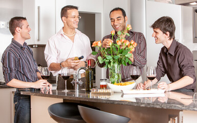 Gay Lifestyle: Arranging Flowers. A group of same sex friends relaxing together and enjoying each others company with a glass of wine. From a series of related images.