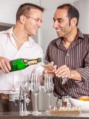 Gay Lifestyle: A moment to celebrate. A same sex couple enjoying each others company and a glass of champagne. From a series of related images.