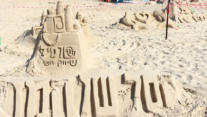 Sandcastle on the beach with umbrella and blue sky in the background,Ashqelon,Israel.