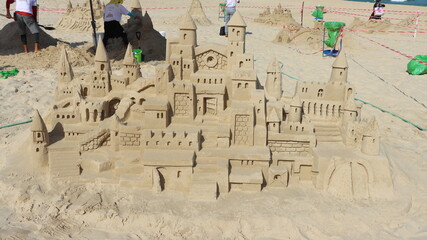 Sandcastle on the beach with umbrella and blue sky in the background,Ashqelon,Israel.
