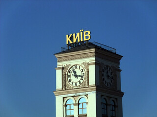 Clock tower with the word “Kyiv” on top under clear blue sky, showcasing historic architecture and timekeeping landmark in Ukraine