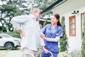 Home caregiver supports elderly man with walker outdoors, both smiling and sharing positive moment,...