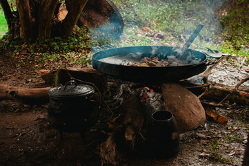 paellera grande sobre el fuego. holla grande tipo disco de hierro, cocinando al aire libre en la naturaleza.